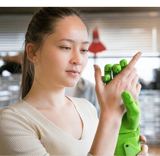 Female engineer examining prosthesis hand project in workshop.