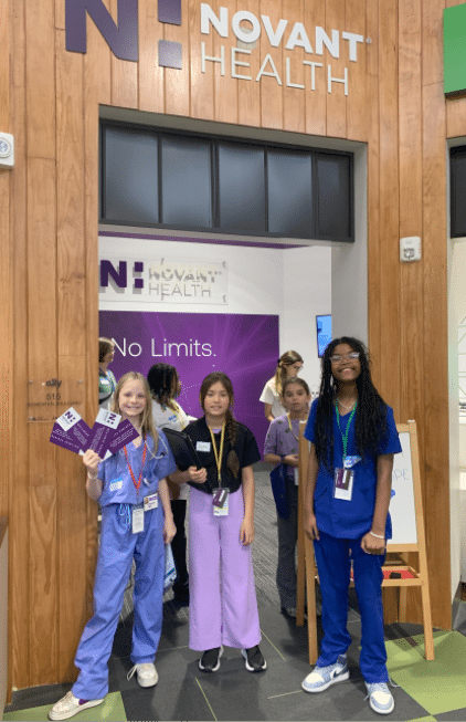 Four people in scrubs pose in front of a sign for Novant Health. AI generated content