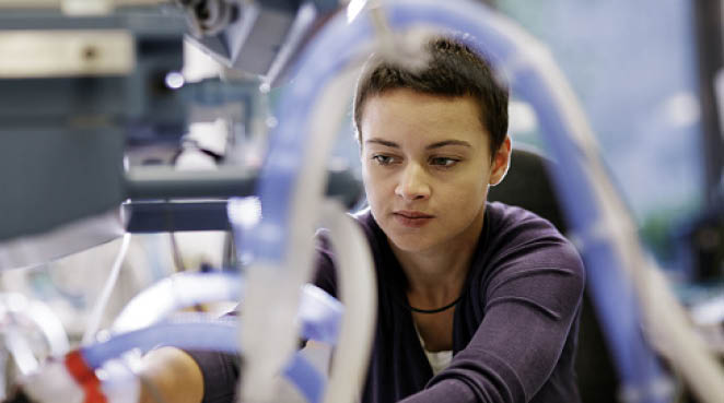 Young female Engineer repairing defect medical device in tech laboratory