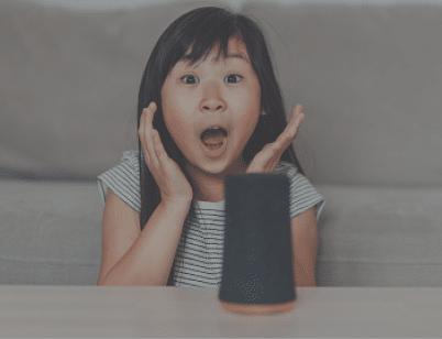 Young Asian girl feeling surprised when talking and listening to smart speaker  Family with smart technology  Smart home can help parents 