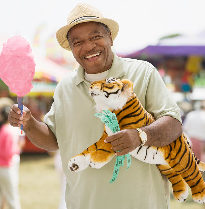 A man is holding a stuffed tiger and a pink cotton candy. AI generated content