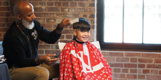 A man is cutting a child's hair with scissors. AI generated content