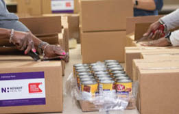 Three women are working together to pack food in boxes. AI generated content