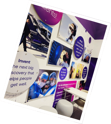 A wall with several posters and a man in a blue shirt standing in front of a helicopter. AI generated content